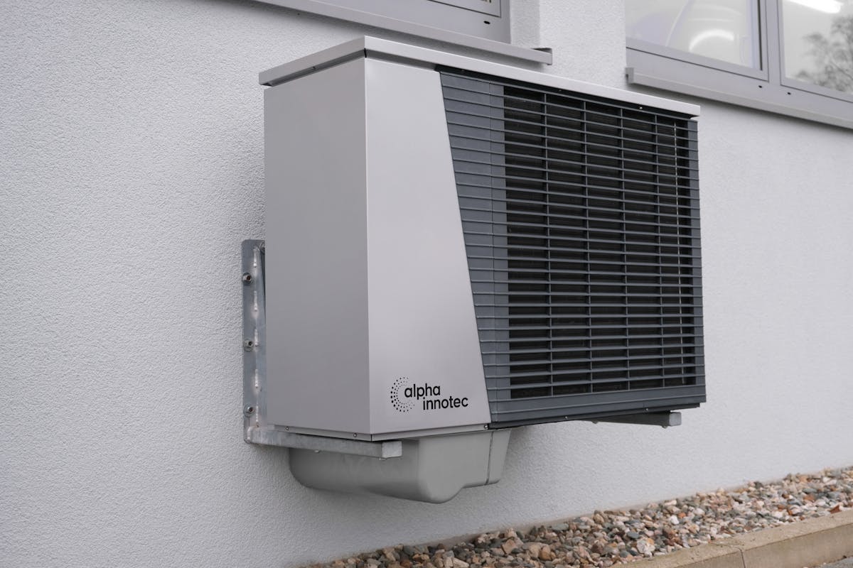 Heat pump unit mounted on exterior wall