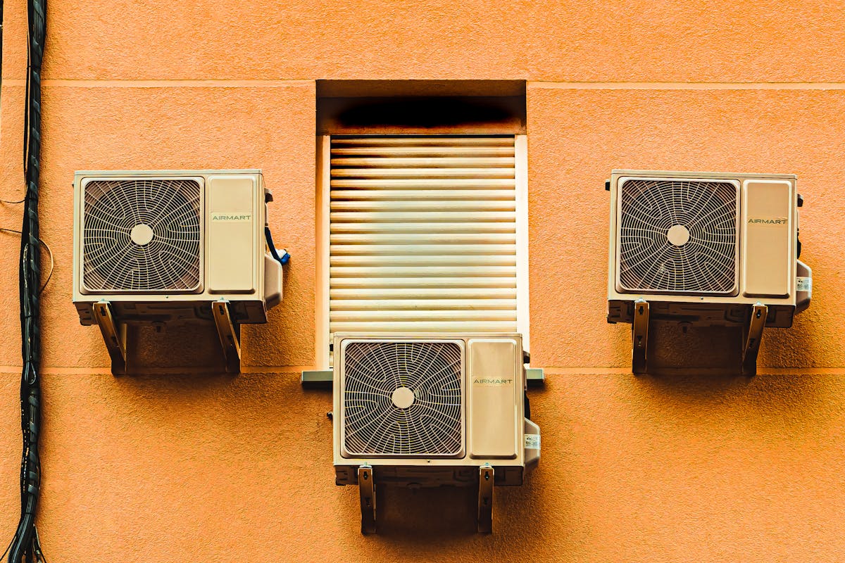 Multiple outdoor air conditioning condenser units on wall
